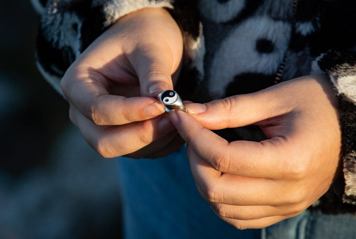 Artist Laura Becker holds a yin-yang ring at a park near her home outside of Milwaukee, Wis., on Nov. 2, 2022. (John Fredricks/The Epoch Times)