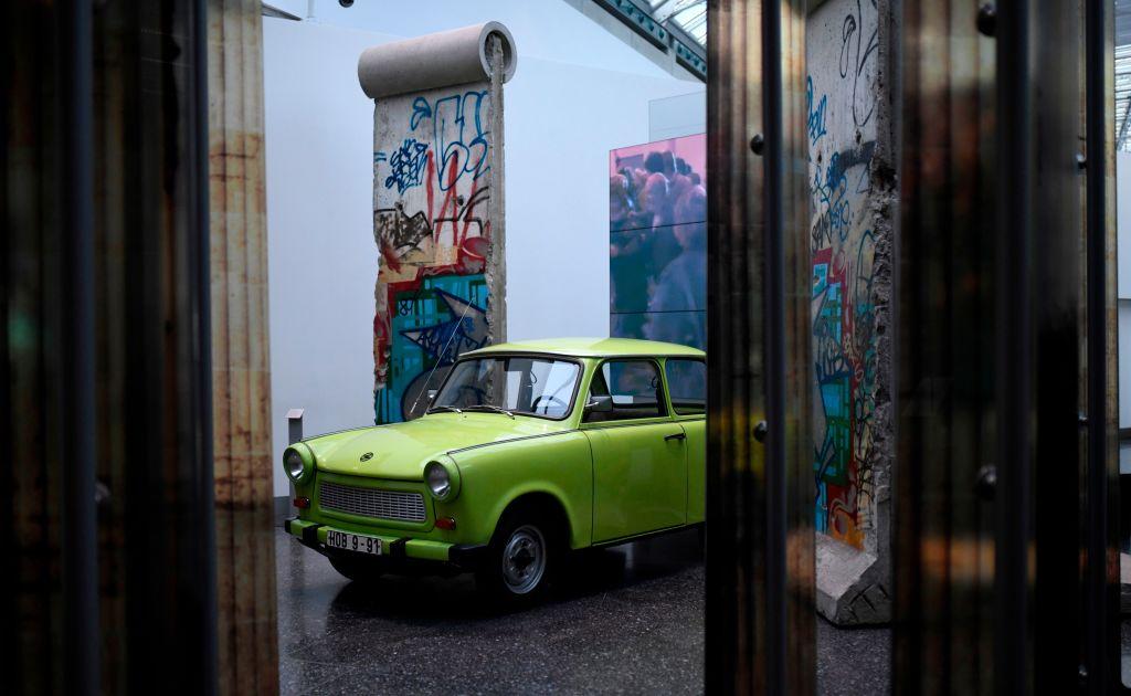 A Trabant car in front of a piece of the Berlin Wall at the Haus der Geschichte in Bonn, western Germany, on Oct. 25, 2019. (Courtesy of INA FASSBENDER/AFP via Getty Images)