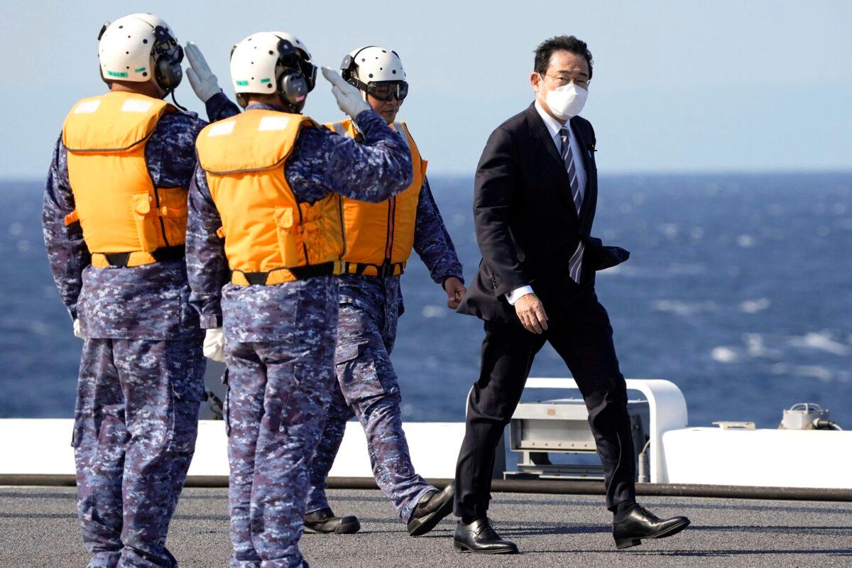 Japanese Prime Minister Fumio Kishida walks on the deck of the Japanese Maritime Self Defense Force's helicopter carrier JS Izumo during an international fleet review in Sagami Bay, southwest of Tokyo, on Nov. 6, 2022. (Kyodo News via AP)