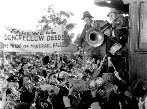 Longfellow Deeds (Gary Cooper) holds a trombone as he leaves his hometown of Mandrake Falls, Vermont in "Mr. Deeds Goes to Town." (MovieStillsDB)