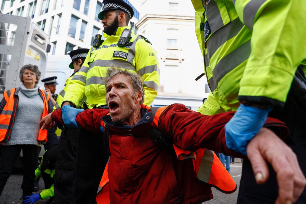 Just Stop Oil protesters are arrested after they blocked the road at the junction of Cannon St. and Queen Victoria St. in London on Oct. 27, 2022. (Jeff Mitchell/Getty Images)