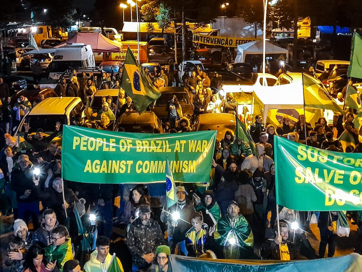 Protesters show a banner in English, reading, “People of Brazil at war against communism” near the Pinheirinho fortress in Curitiba Brazil, on Nov. 4, 2022. (Frederico Vidovix/The Epoch Times)