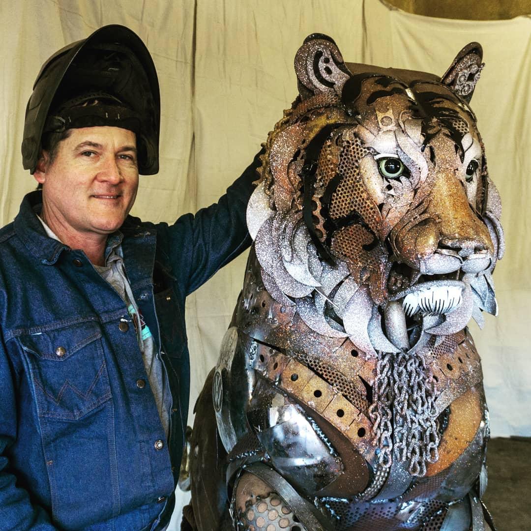 John Lopez and a tiger made of scrap metal. (Courtesy of <a href="https://www.instagram.com/johnlopezstudio/">John Lopez</a>)