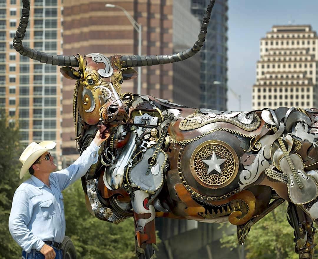 John Lopez poses beside his sculpture of a bull. (Courtesy of <a href="https://www.instagram.com/johnlopezstudio/">John Lopez</a>)