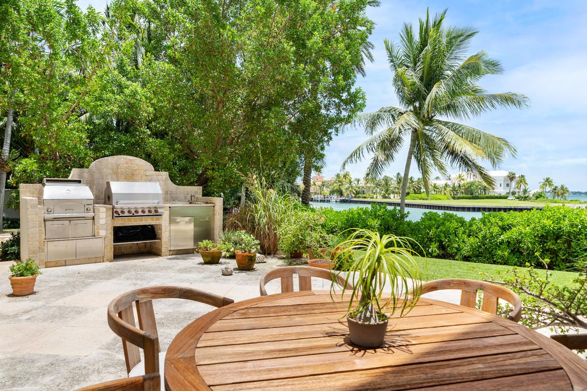 The al fresco dining area features a well-equipped outdoor kitchen and panoramic views of the tropical scenery. (Courtesy of Damianos Sotheby’s International Realty)