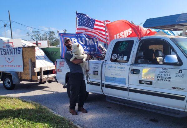 Joshua Pearce, of Port Charlotte, Fla., stands with his service dog, Kyra, outside a polling place on Nov. 8, 2022. He said he was told to leave before casting a ballot because his truck—decorated with conservative political messaging—would not be allowed in the parking lot. (Jann Falkenstern/The Epoch Times)