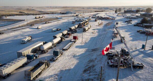 A truck convoy of anti-COVID-19 vaccine mandate demonstrators block the highway at the busy U.S. border crossing in Coutts, Alta., on Feb. 2, 2022. (The Canadian Press/Jeff McIntosh)