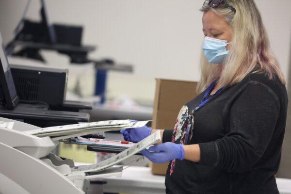An elections worker scans mail-in ballots at the Maricopa County Tabulation and Election Center in Phoenix, on Nov. 7, 2022. (Justin Sullivan/Getty Images)