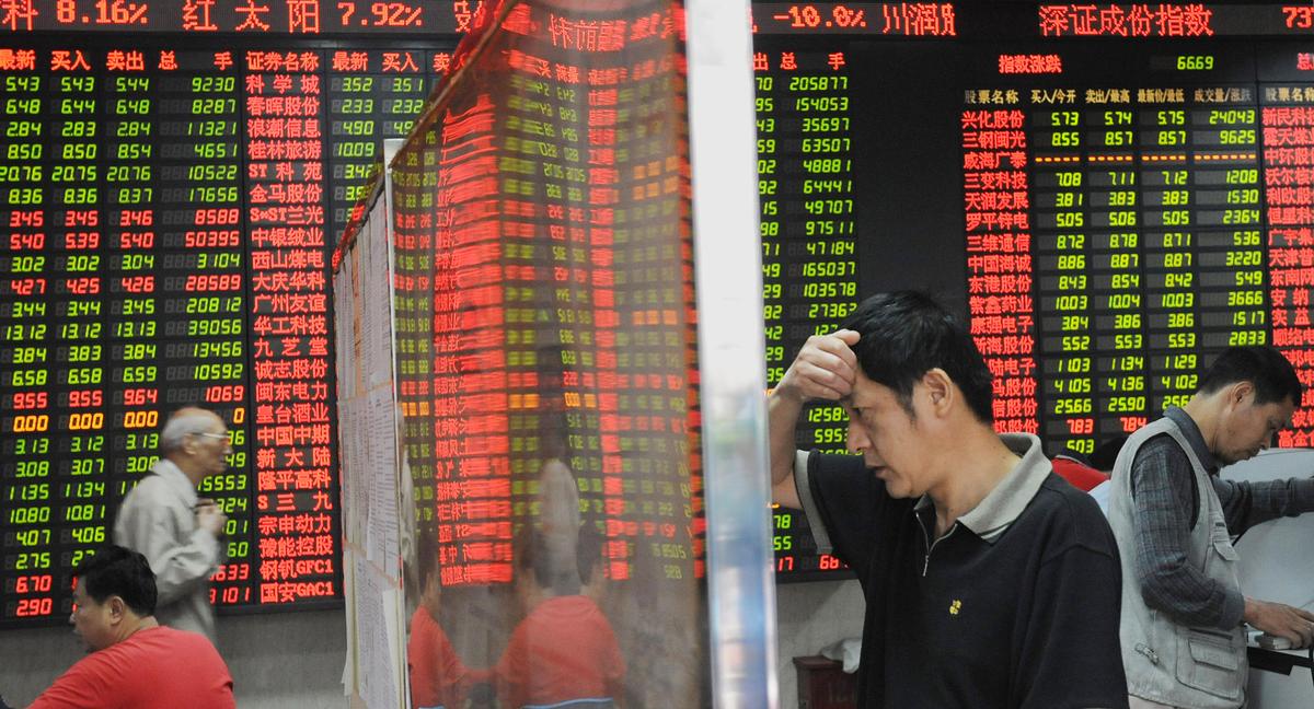Chinese investors in front of a stock price board showing falling prices at a private security firm in Shanghai on Oct. 6, 2008. (Mark Ralston/AFP via Getty Images)