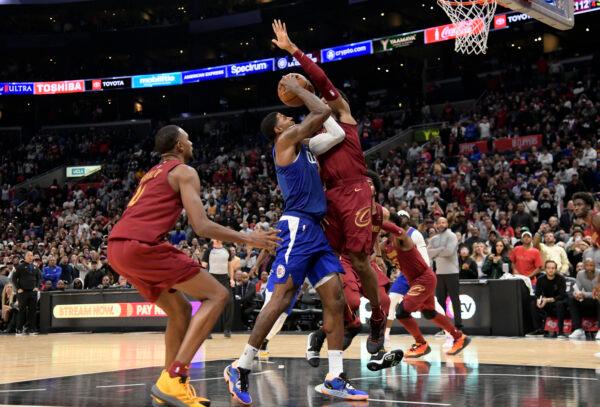 Paul George (13) of the Los Angeles Clippers is fouled by Isaac Okoro (35) of the Cleveland Cavaliers but completed the three-point play in the second half at Crypto.com Arena in Los Angeles, on Nov. 7, 2022. (Kevork Djansezian/Getty Images)