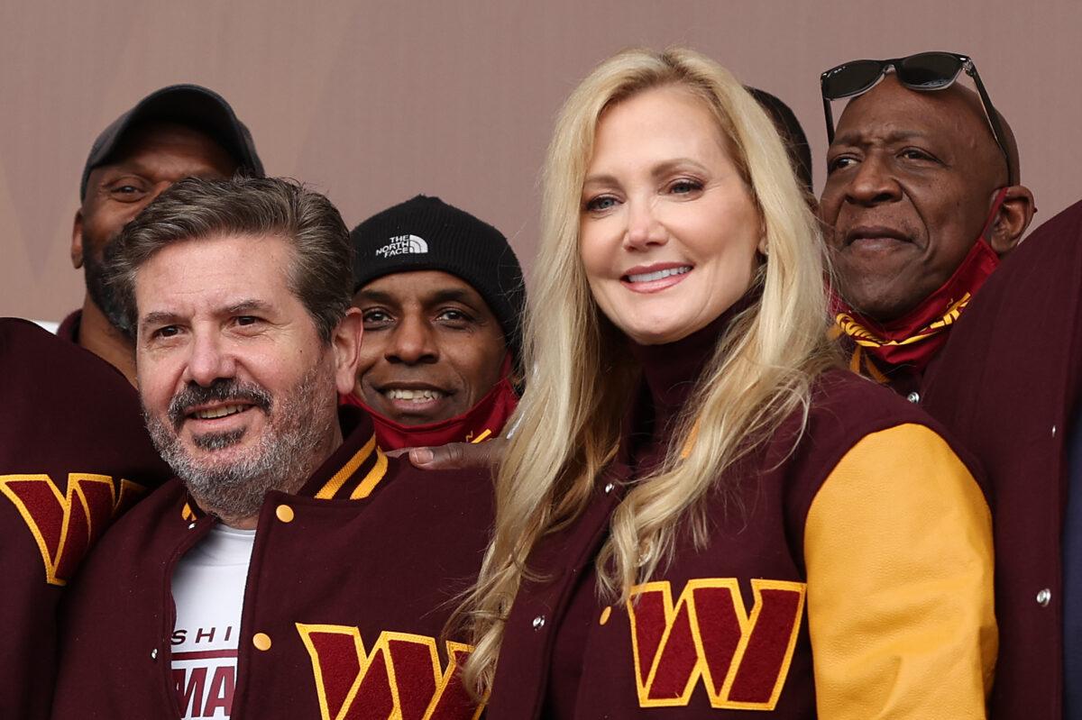 Team co-owners Dan and Tanya Snyder pose for a photo with former team members during the announcement of the Washington Football Team's name change to the Washington Commanders at FedExField in Landover, Maryland on Feb. 2, 2022. (Rob Carr/Getty Images)