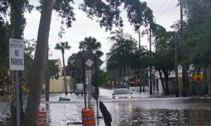 Moments before becoming stranded on a hidden concrete platform, an elderly driver maneuvers down a flooded street in St. Augustine, Fla., on Nov. 10, 2022. (Natasha Holt/The Epoch Times)