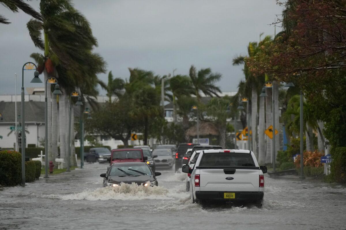 Drivers navigate a flooded street following the passage of Hurricane Nicole in Fort Pierce, Fla., on Nov. 10, 2022. (Rebecca Blackwell/AP Photo)