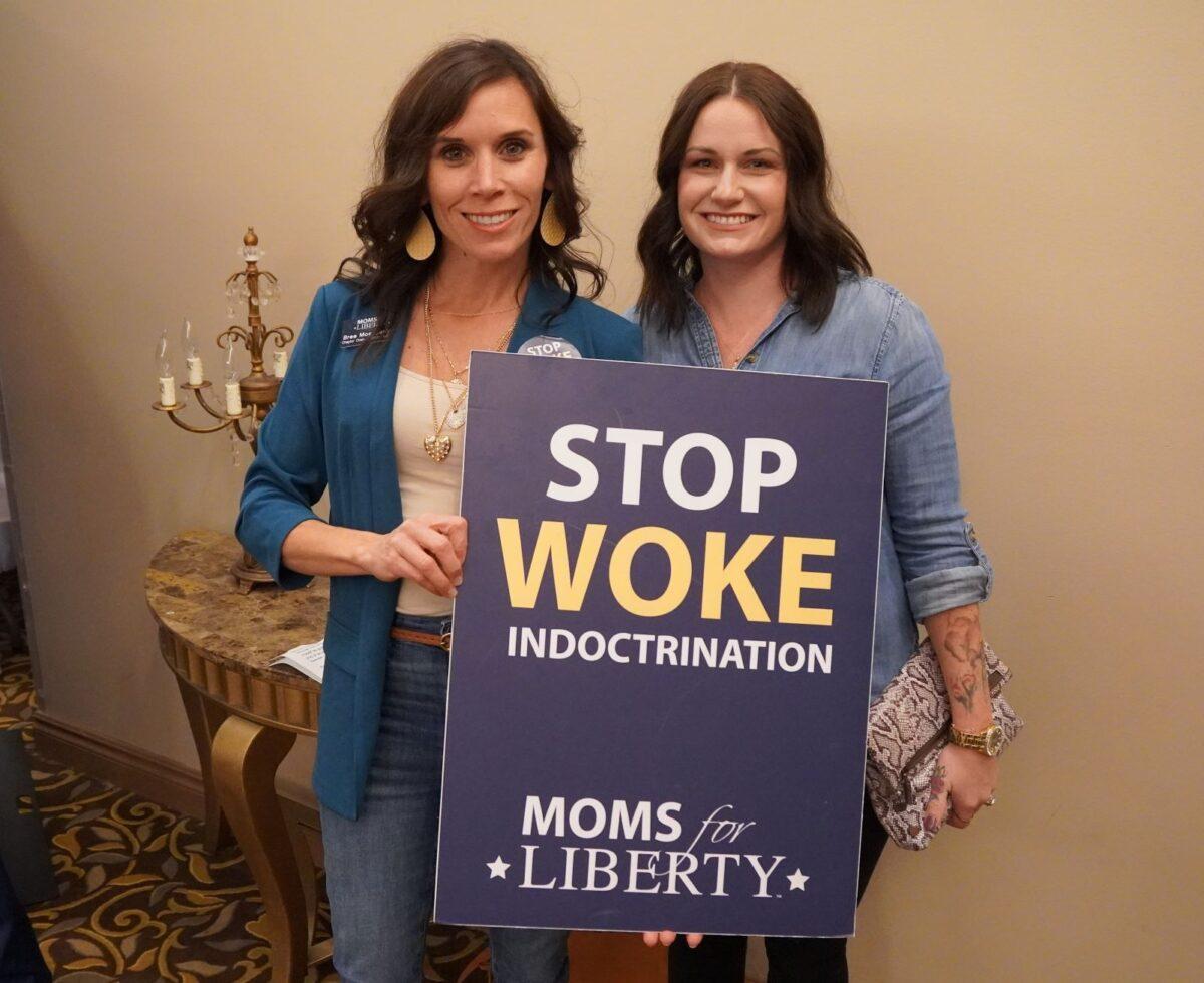 A mother and daughter show they oppose school curriculums that indoctrinate children with radical "woke" ideology during a Moms for Liberty rally in Troy, Mich. on Oct. 14, 2022. (Steven Kovac/The Epoch Times)