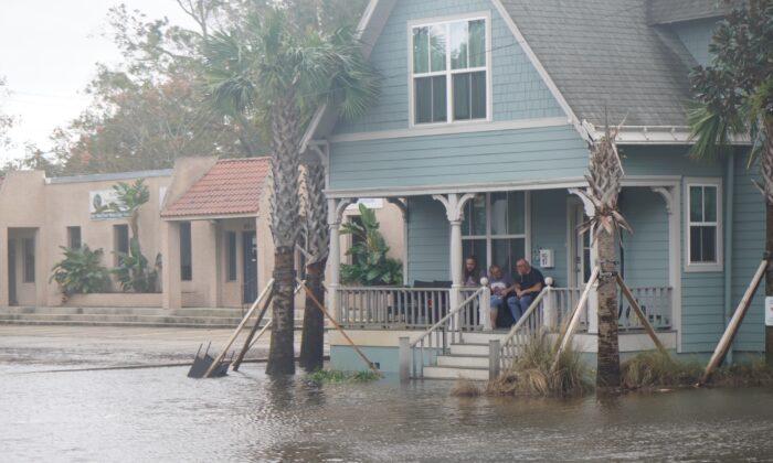 Residents of St. Augustine, Fla., watch the rising floodwaters from the porch of their inland home on Nov. 10, 2022. (Natasha Holt/The Epoch Times)