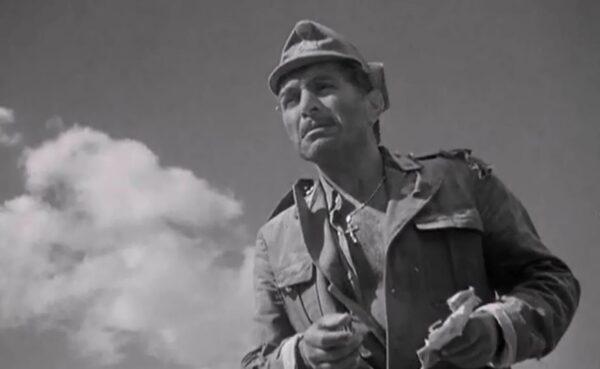 Italian prisoner of war Giuseppe (J. Carrol Naish) gathers up pictures and letters from his wife back home as he is left stranded in the desert, in “Sahara.” (Columbia Pictures)