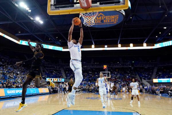 UCLA guard Jaylen Clark (0) dunks past Long Beach State guard Jadon Jones, left, during the first half of an NCAA college basketball game in Los Angeles, Nov. 11, 2022. (Marcio Jose Sanchez/AP Photo)