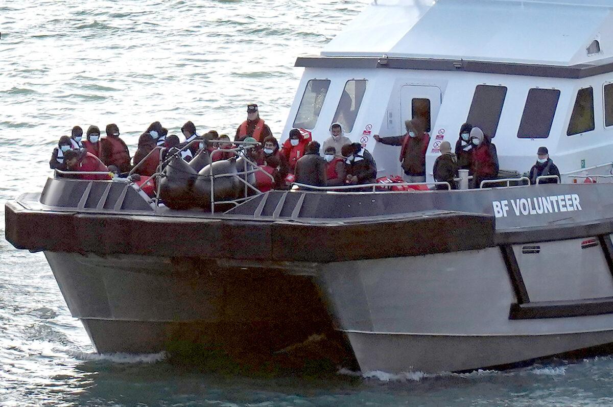 A group of illegal immigrants is brought to the port of Dover, England, after their small boat was intercepted in the English Channel on Oct. 9, 2022. (PA Media)