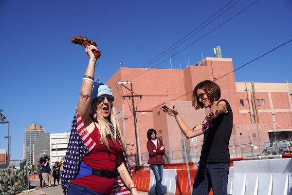 Conservative Republican activist Angie Russo (R) dances with a participant at a prayer rally outside the Maricopa County Tabulation and Election Center in Phoenix, Ariz., on Nov. 14, 2022. (Allan Stein/The Epoch Times)