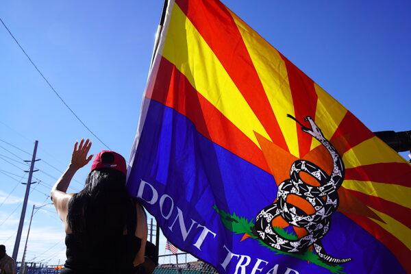 A woman holds an Arizona "Gadsden Flag" during a post-election prayer rally in Phoenix on Nov. 14, 2022. (Allan Stein/The Epoch Times)