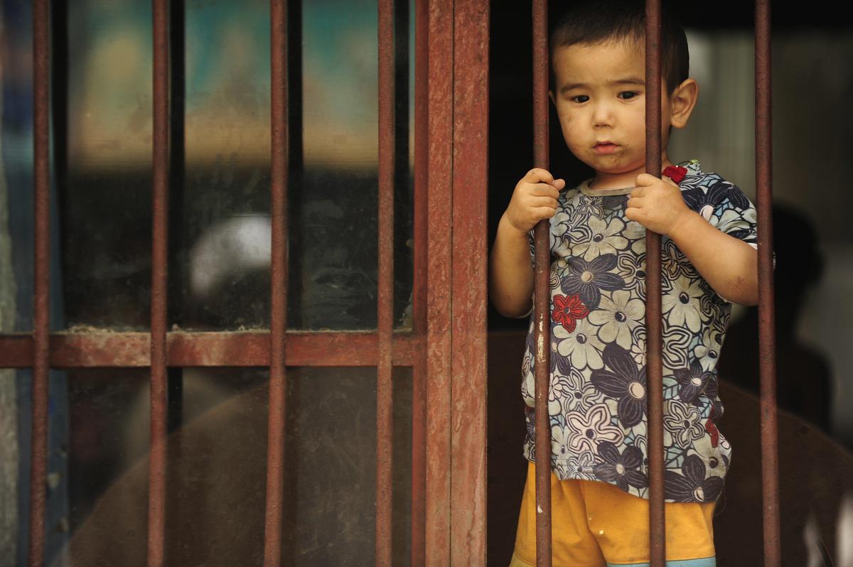 A young ethnic Uyghur boy looks out from his home in the Uyghur area in the city of Urumqi in China's Xinjiang region on July 12, 2009. (Peter Parks/AFP via Getty Images)