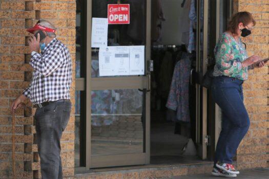 Shoppers check their phones whilst moving along Bong Bong Street in Bowral, New South Wales, Australia, on Oct. 29, 2021. (Lisa Maree Williams/Getty Images)