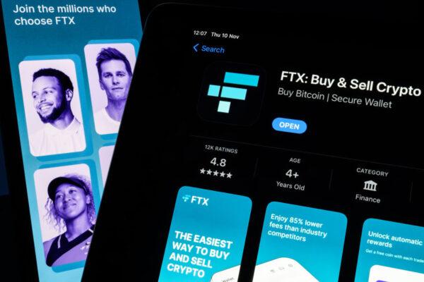 In this photo illustration, the FTX logo and mobile app adverts are displayed on screens in London, England, on Nov. 10, 2022. The Bahamas-based crypto exchange's larger rival, Binance, walked away from a potential bailout deal as FTX struggles with a wave of customer withdrawals that have created a liquidity crunch. (Leon Neal/Getty Images)