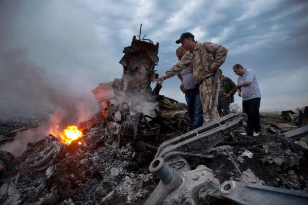 People inspect the crash site of a passenger plane near the village of Grabovo, Ukraine, on July 17, 2014. (Dmitry Lovetsky/AP Photo)