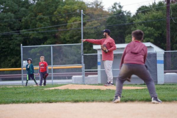 Brian Lattimer coaches a team on a field in Otisville, N.Y., on Sept. 30, 2022. (Cara Ding/The Epoch Times)