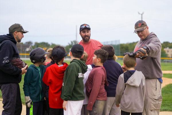 Dan Brown (right) encourages a kid after a training session of the Otisville Little League in Otisville, N.Y., on Sept. 30, 2022. (Cara Ding/The Epoch Times)