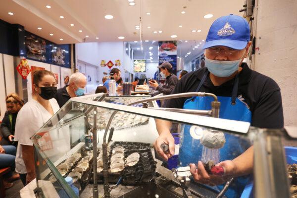 A staff member shucks oysters at the Sydney Fish Market in Sydney, Australia, on April 14, 2022. (Lisa Maree Williams/Getty Images)