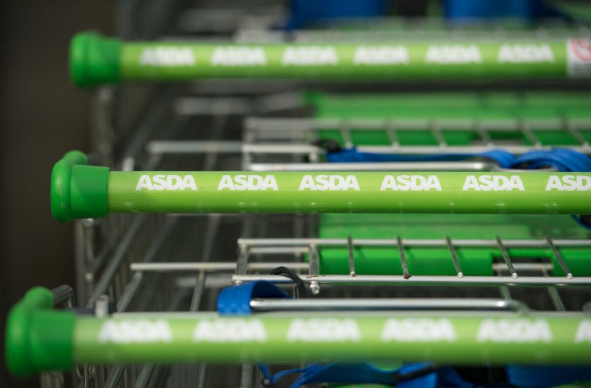 Logos of supermarket chain Asda are pictured on the handles of shopping trolleys outside a store in Stockport, northern England, on April 30, 2018. (Oli Scarff/AFP via Getty Images)