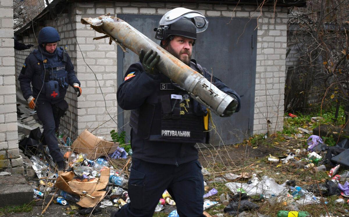 A Ukrainian sapper carries a part of a projectile during a demining operation in a residential area in Lyman, Donetsk region, Ukraine, on Nov. 16, 2022. (Andriy Andriyenko/AP Photo)