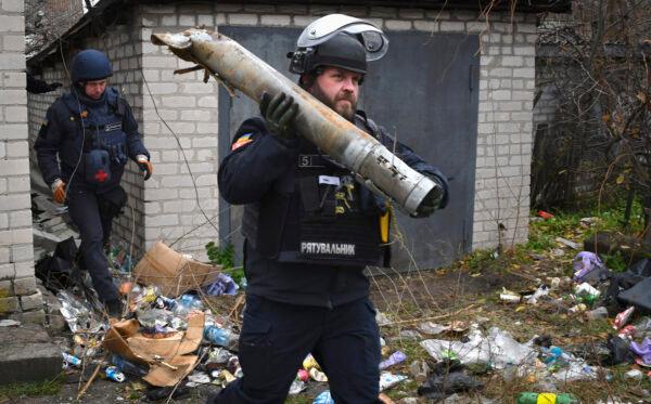 A Ukrainian sapper carries a part of a projectile during a demining operation in a residential area in Lyman, Donetsk region, Ukraine on Nov. 16, 2022. (Andriy Andriyenko/AP Photo)