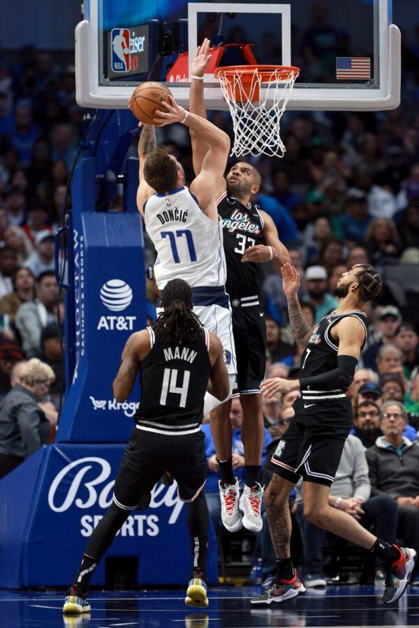 Luka Doncic (77) of the Dallas Mavericks drives to the basket against Terance Mann (14), Nicolas Batum (33) and Amir Coffey (7) of the LA Clippers in the second half at American Airlines Center in Dallas, on Nov. 15, 2022. (Tom Pennington/Getty Images)