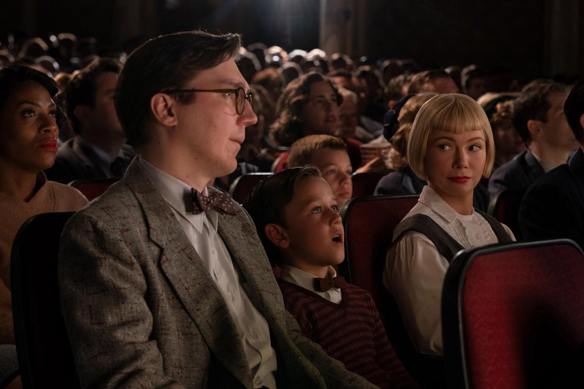 (L–R) Burt Fabelman (Paul Dano), young Sammy Fabelman (Mateo Zoryon Francis-DeFord), and Mitzi Fabelman (Michelle Williams) sit in a movie theater, in "The Fabelmans." (Merie Weismiller Wallace/Universal Pictures)
