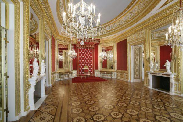 French and Italian masters created the interior decor in the gold and crimson Throne Room. Five huge crystal mirrors reflect the stucco work, paneled walls, and marble fireplaces imported from Rome. Italian sculptor Angelo Puccinelli created sculptures of ancient Roman rulers to convey the virtues of wisdom, justice, restraint, and courage. (A. Ring/Royal Castle in Warsaw)