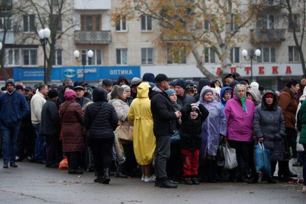 People wait for food aid after Russia's retreat from Kherson in Ukraine on Nov. 17, 2022. (Murad Sezer/Reuters)