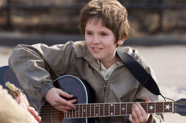 A young and gifted Evan aka August Rush (Freddie Highmore) hopes music will help him find his parents. (MovieStillsDB)