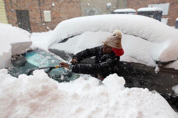 Zaria Black, 24, from Buffalo, clears off her car as snow falls, in Buffalo, N.Y., on Nov. 18, 2022. (Joshua Bessex/AP Photo)