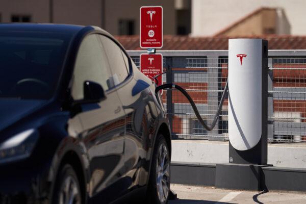 A Tesla vehicle is plugged into a Tesla charging station in a parking lot in Santa Monica, Calif., on Sept. 22, 2022. (Allison Dinner/Getty Images)