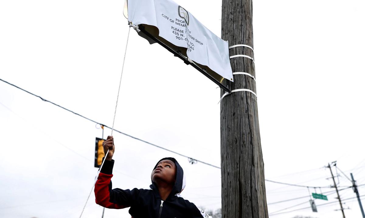 Young Dolph's son, Tre Tre, helps unveil a new street sign at a street naming ceremony honoring Young Dolph in Memphis, Tenn., on Dec. 15, 2021. (Patrick Lantrip/Daily Memphian via AP)