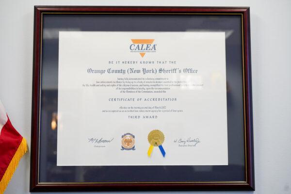 A certificate of CALEA accreditation in the Orange County Sheriff's Office in Goshen, N.Y., on Nov. 19, 2022. (Cara Ding/The Epoch Times)