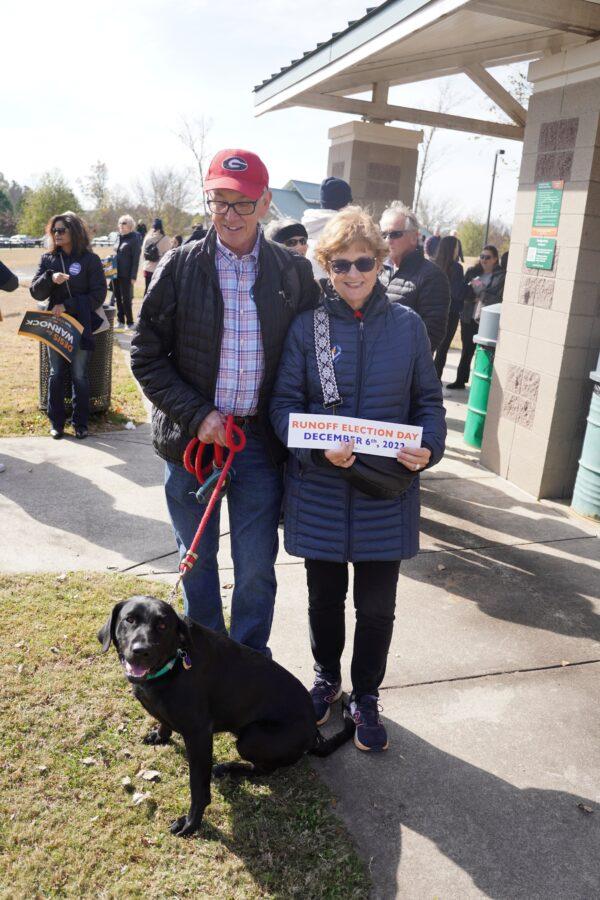 Charles and Linda Purcell of Roswell and their dog Boone at a rally for Raphael Warnock in Fowler Park, Cumming, Ga., on Nov. 19, 2022. (Dan M. Berger/The Epoch Times)