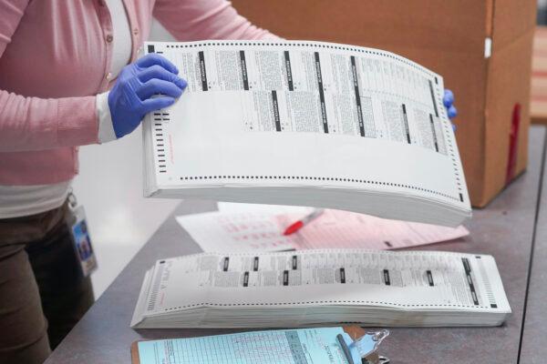 An election worker gathers tabulated ballots to be boxed in a file photo. (Matt York/AP Photo)