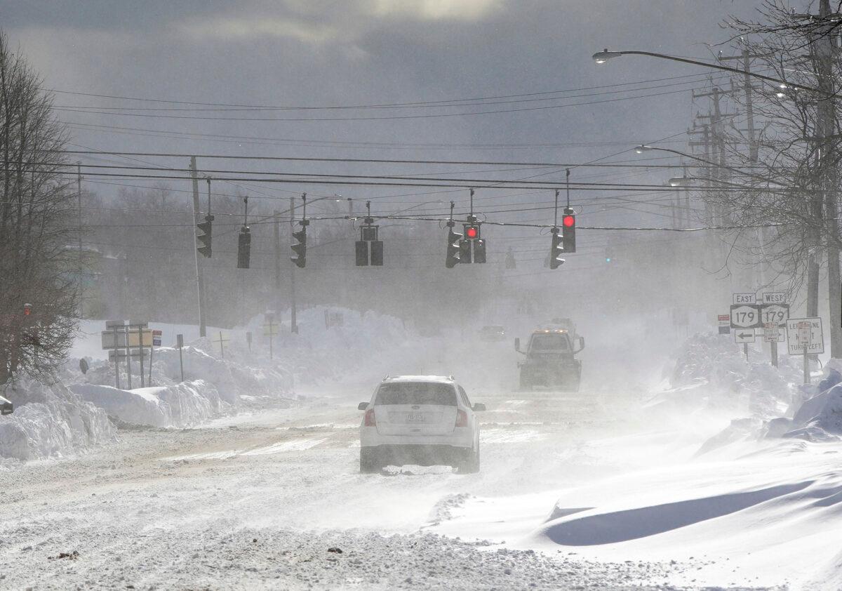 Cars drive through blowing, drifting snow on McKinley Parkway in Hamburg in Erie County, N.Y., on Nov. 20, 2022. (Mark Mulville/The Buffalo News via AP)