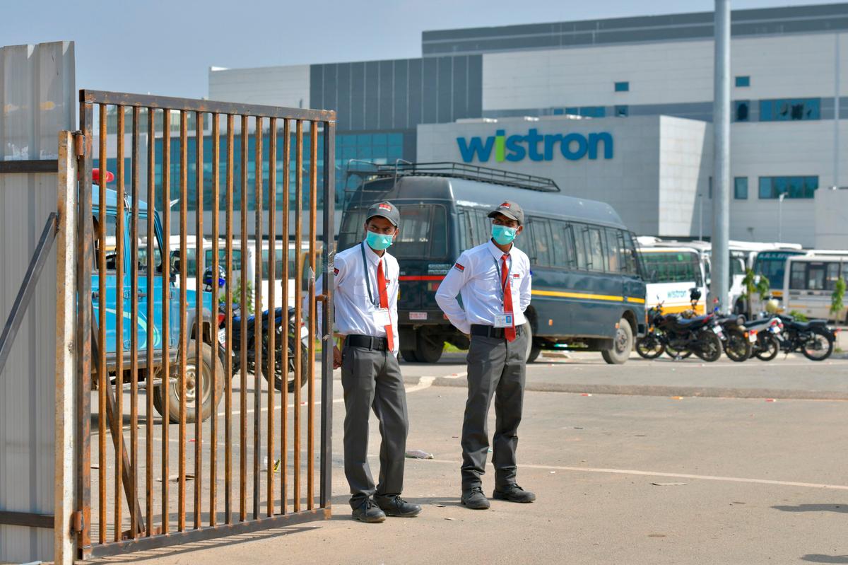 Private security personnel guards the entrance of a Taiwanese-run iPhone factory at Narsapura, about 60 km from Bangalore, India, on Dec. 13, 2020.  (Photo by Manjunath Kiran / AFP via Getty Images)