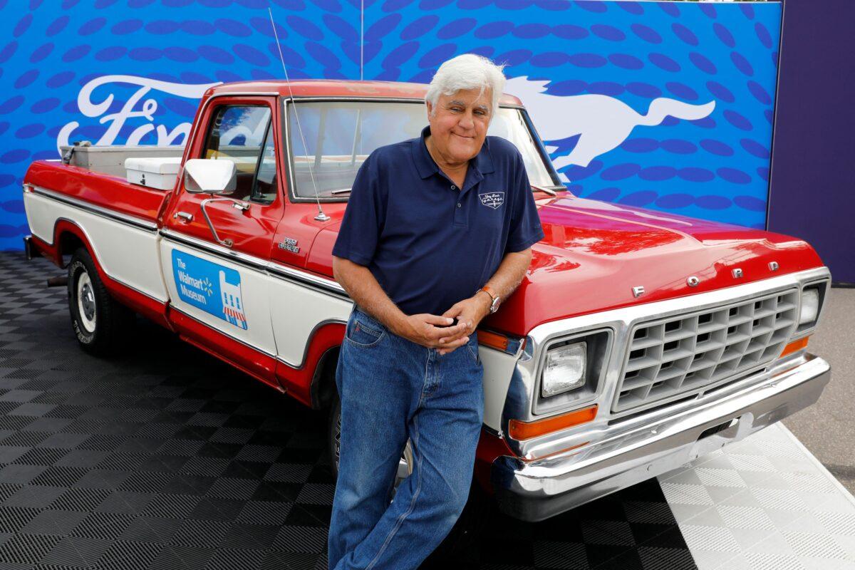 U.S. comedian Jay Leno poses in front of a 1979 Ford F-150 pickup, in the style of one owned by Walmart founder Sam Walton during the 27th annual Woodward Dream Cruise, in Royal Oak, Mich., on Aug. 20, 2022. (Jeff Kowalsky/AFP via Getty Images)