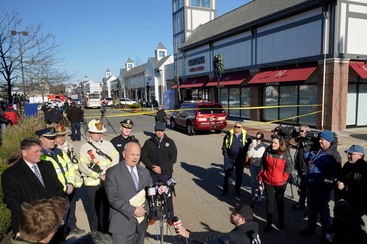 Plymouth County District Attorney Timothy Cruz, center left, speaks to reporters near a scene where an SUV crashed into Apple store in Hingham, Mass., on Nov. 21, 2022. (Steven Senne/AP Photo)