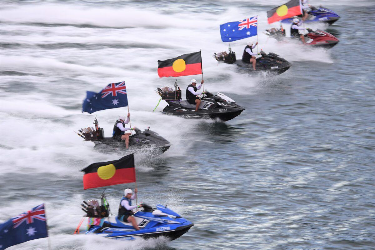 Jetski’s fly the Australian and Aboriginal flags during Australia Day celebrations at Circular Quay, in Sydney, Australia, on Jan. 26, 2021. (AAP Image/Dan Himbrechts)
